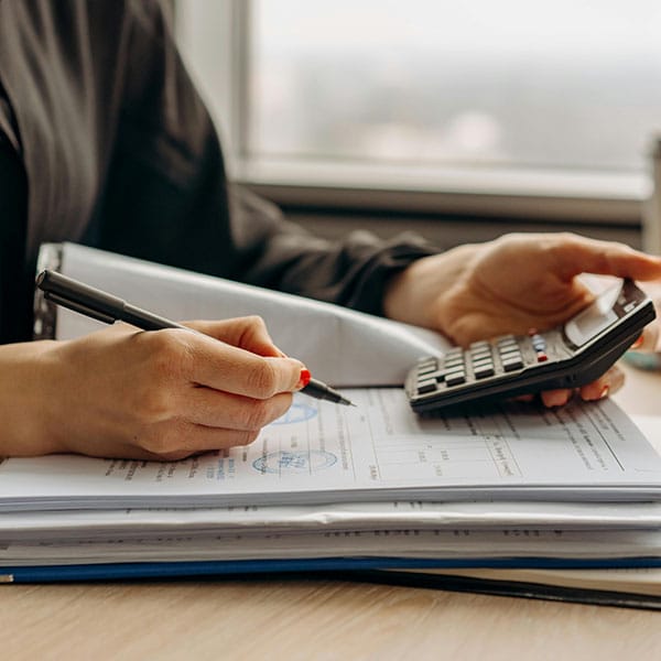 a person using a calculator and pen